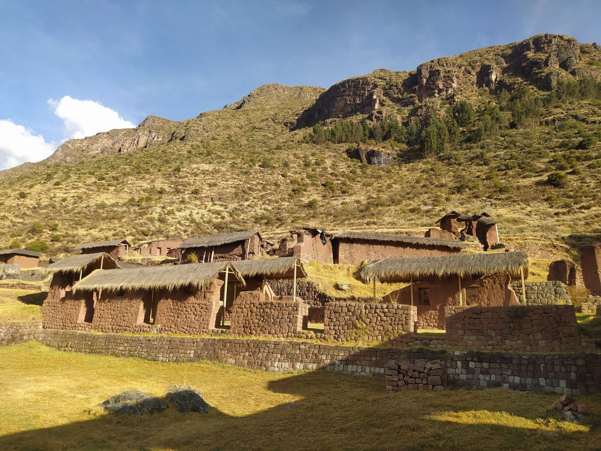 Rectangular Inca buildings with thatched roofs at Huchuy Qosqo, Cusco