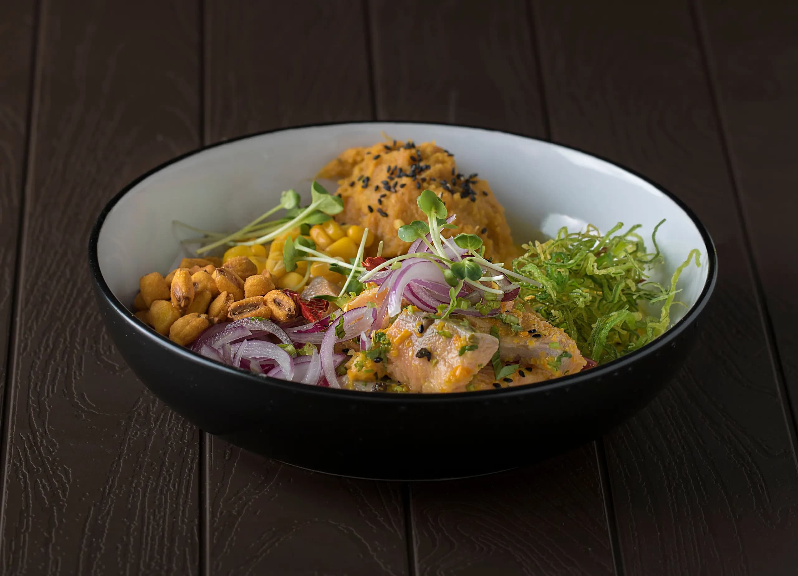 Ceviche served with corn, onion, lettuce and side dishes