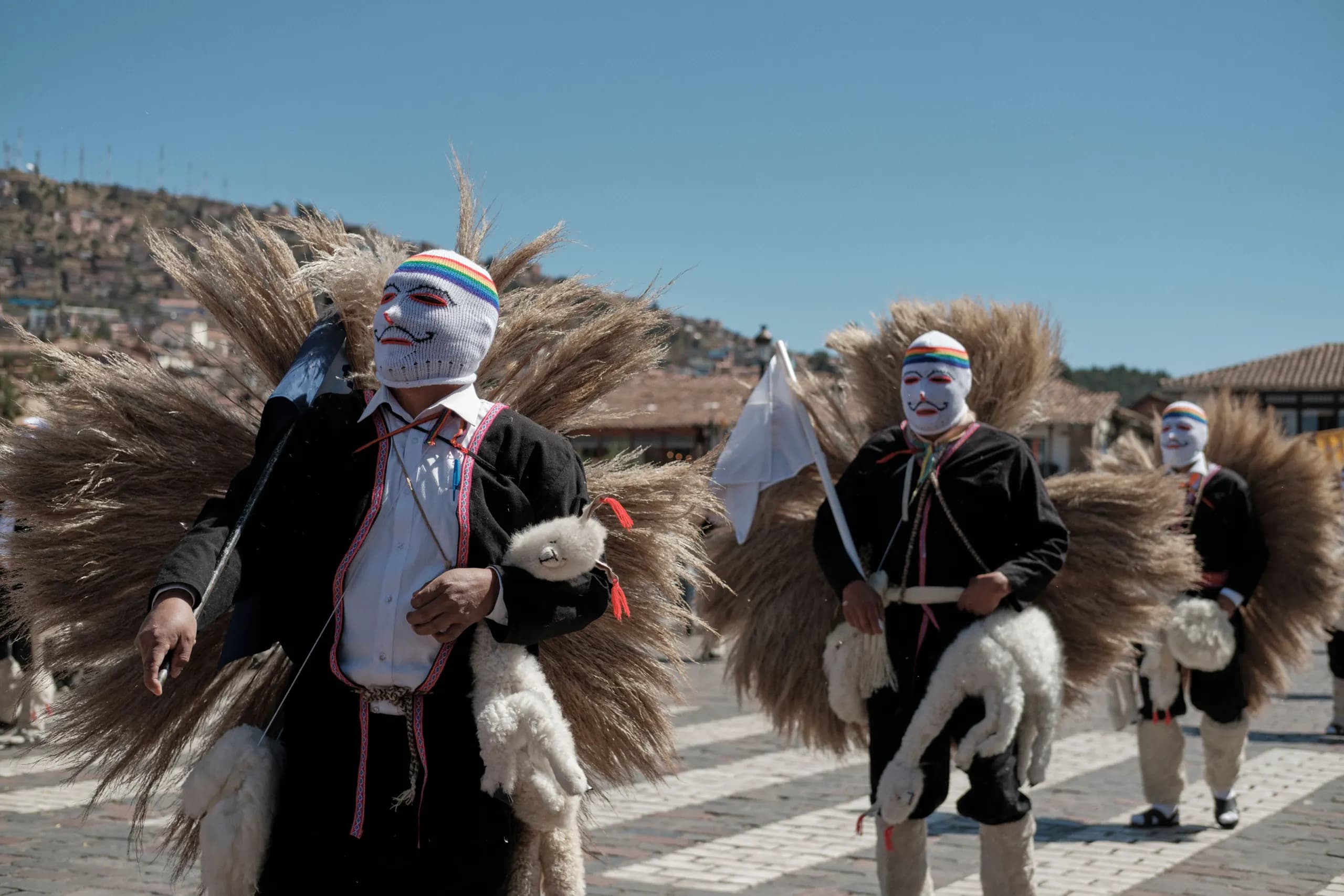 Dancers wearing masks and traditional Andean clothing