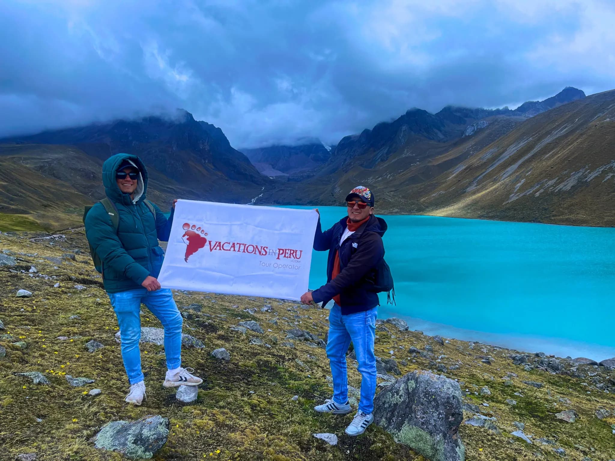 Travellers with the Vacations in Peru flag beside Lake Singrenacocha