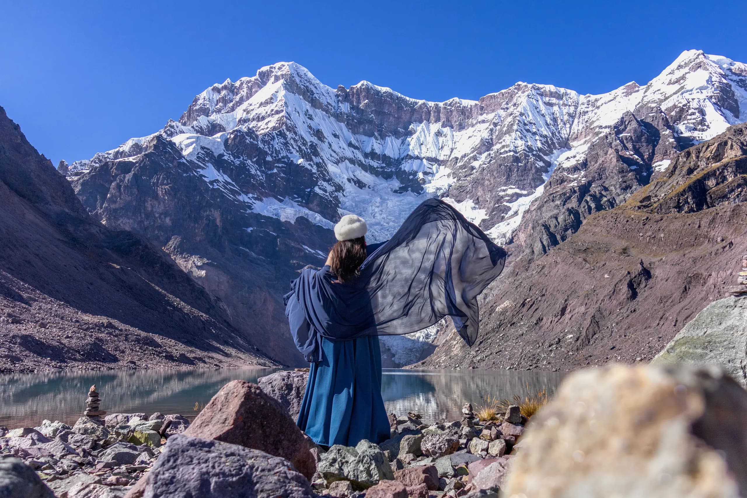 A person looking towards Humantay Lake and the snow-covered Salkantay peaks