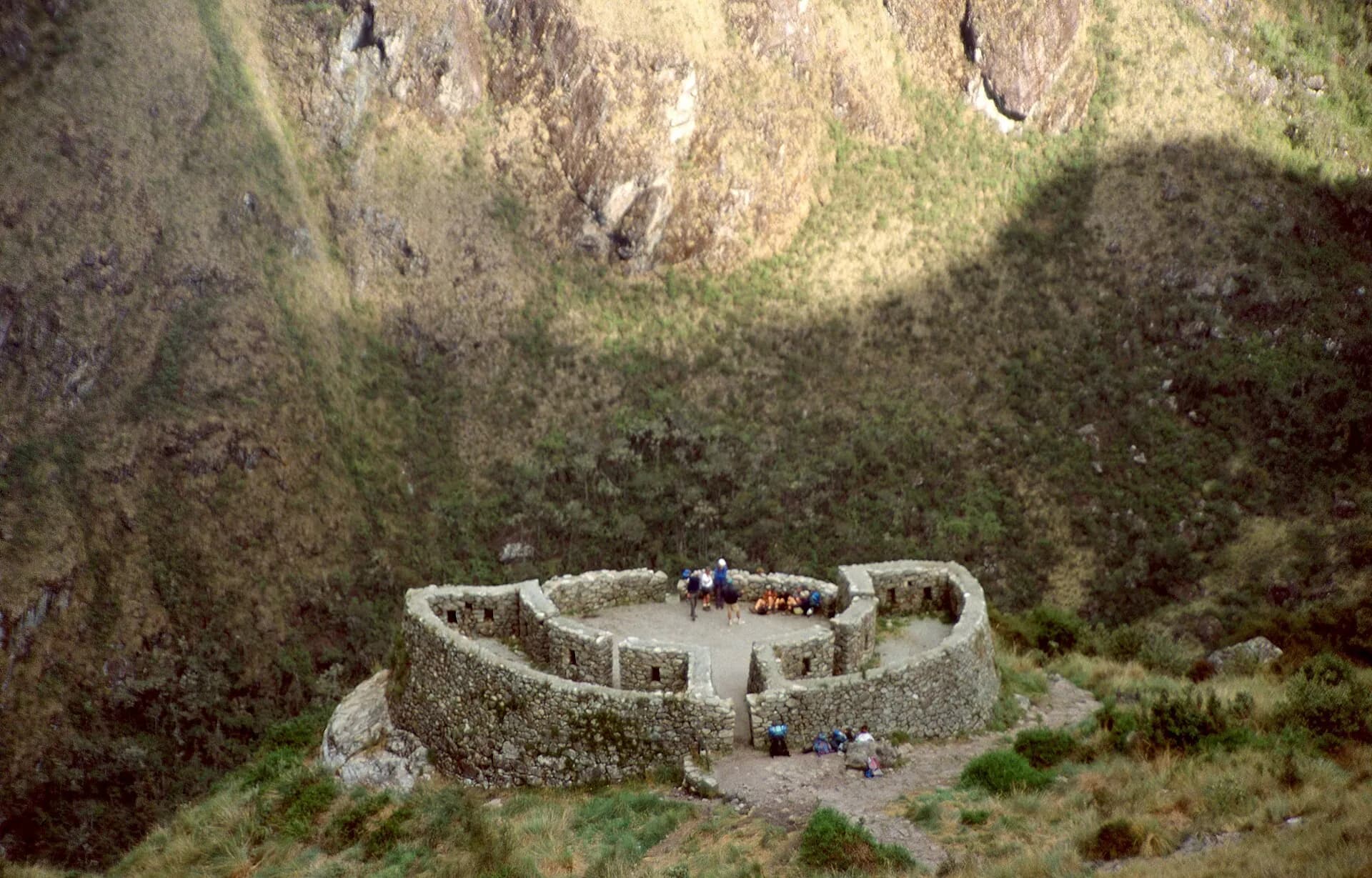 Circular Runkurakay ruin on a mountainside along the Inca Trail