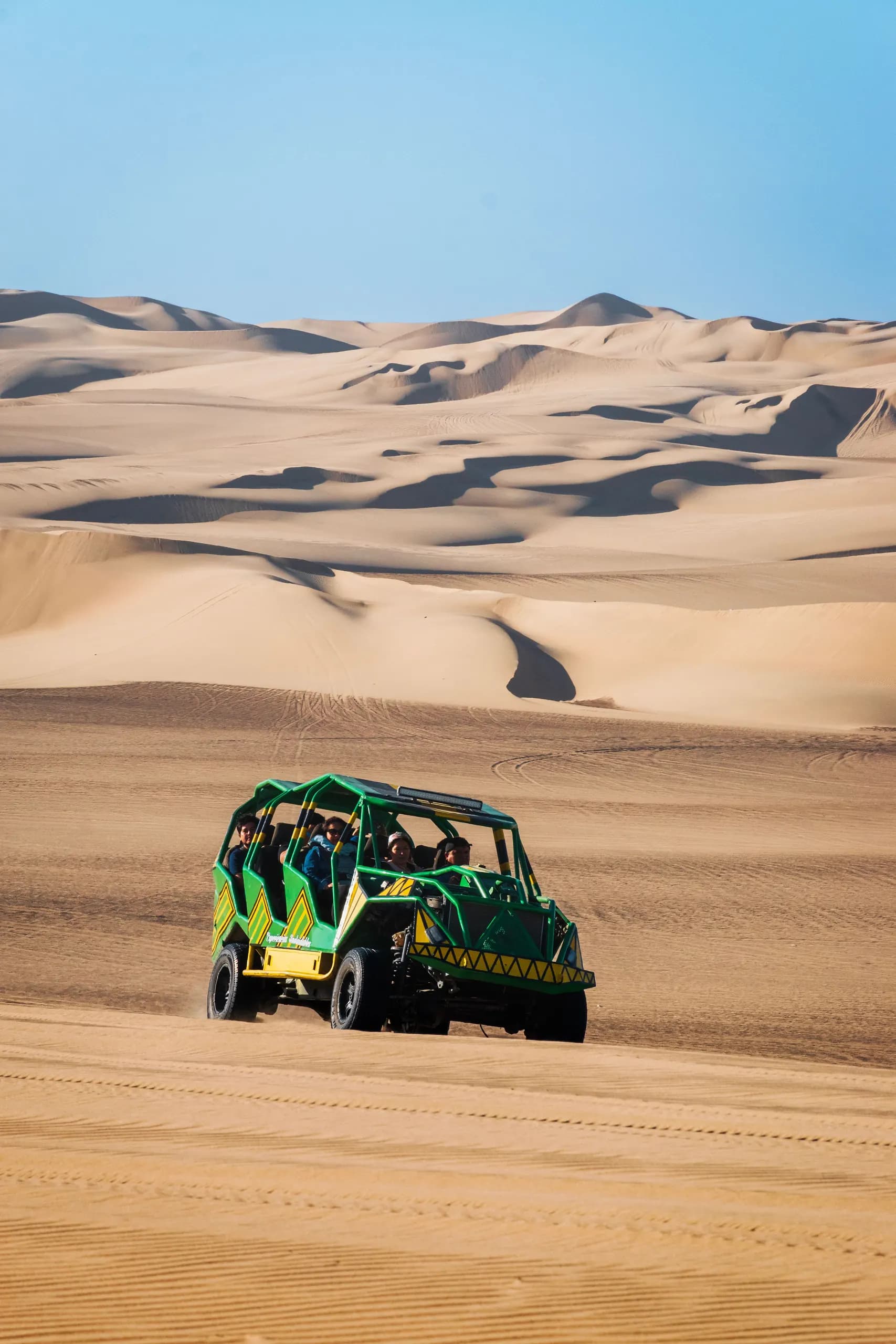 © gilmerdiaz · Pexels Green dune buggy crossing the sand dunes of Huacachina beneath a clear sky